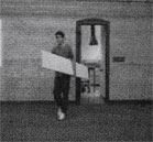 Кадр из триады (человек выносит доску из комнаты)